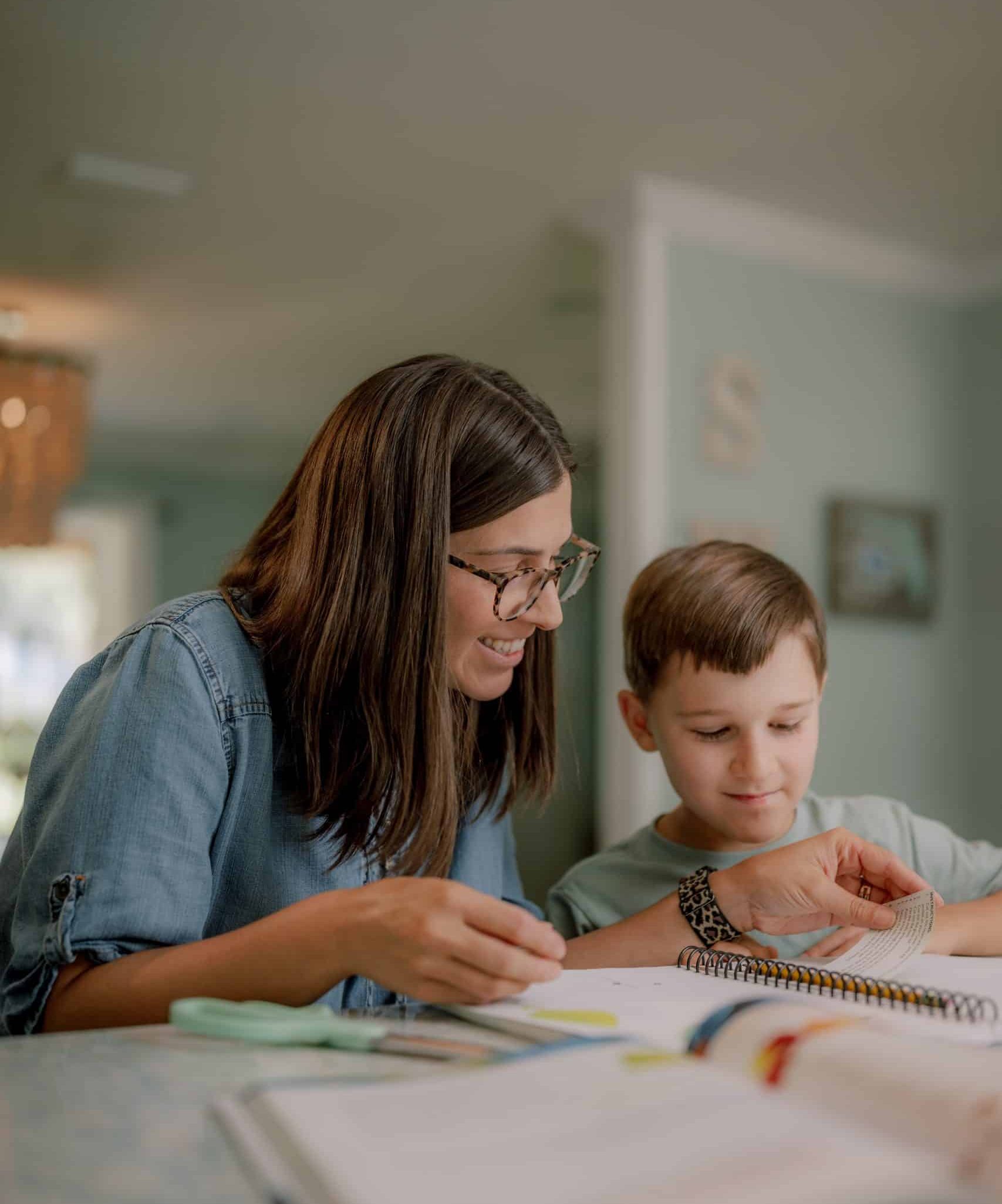 mom helping son with math at kitchen table